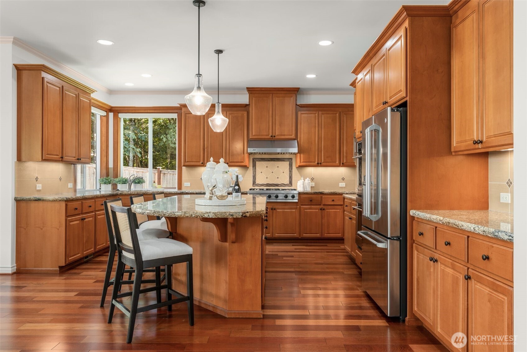 2022 240th Place Southeast Bothell, WA 98021 - Photo 19 of 40 a kitchen with stainless steel appliances kitchen island granite countertop a refrigerator a stove top oven a sink dishwasher and wooden cabinets with wooden floor