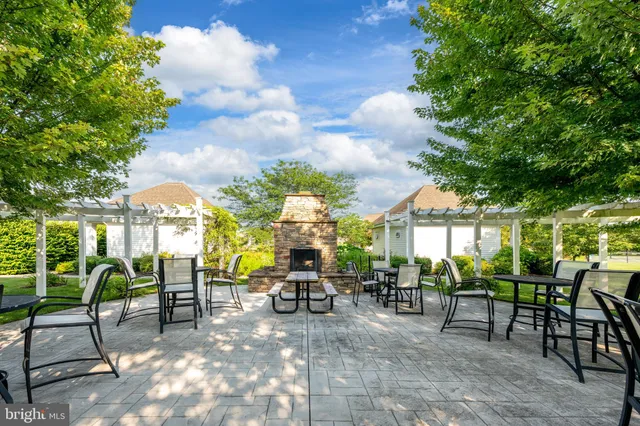 a view of a patio with dining table and chairs with a barbeque grill and plants