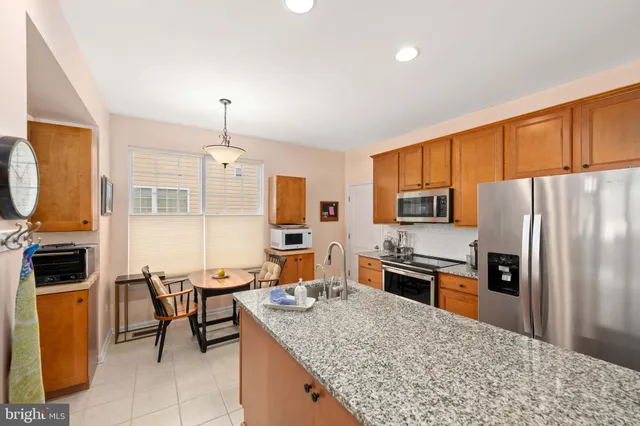 a kitchen with stainless steel appliances granite countertop a stove refrigerator and a sink