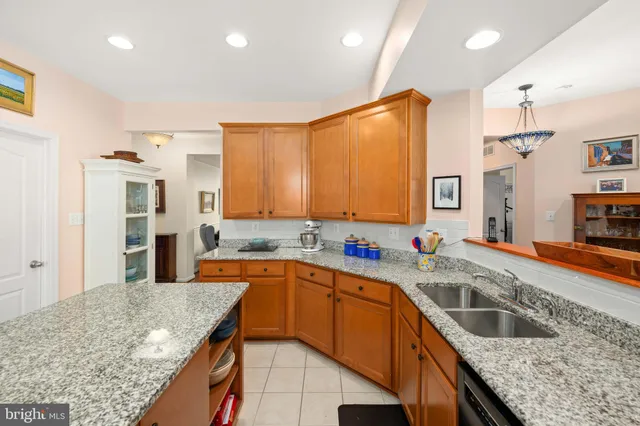 a kitchen with stainless steel appliances granite countertop a sink a stove and a refrigerator