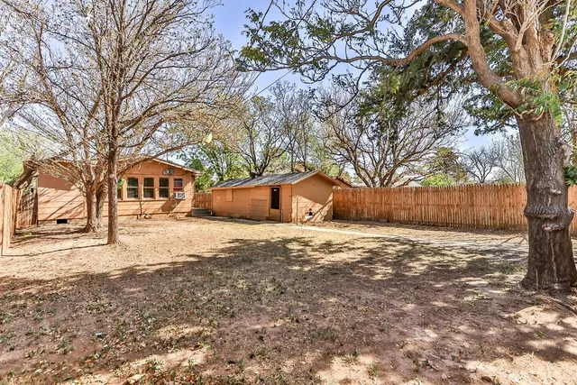 a wooden bench sitting in middle of a yard
