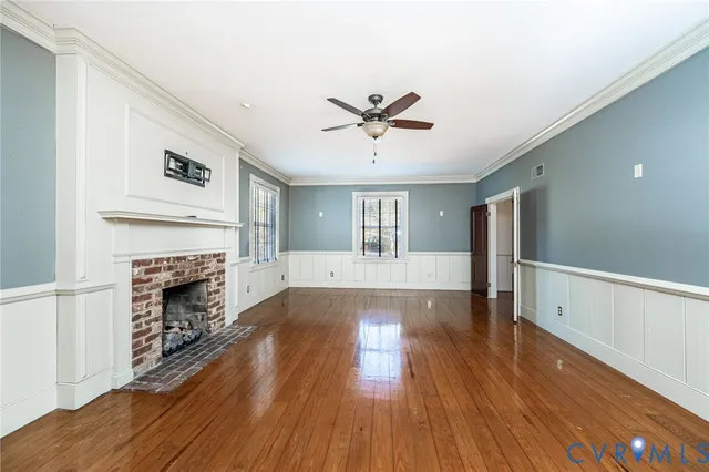 a view of empty room with wooden floor and fireplace