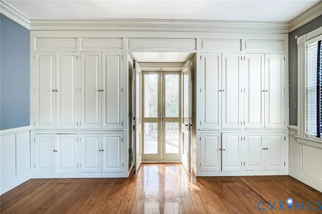 a view of empty room with wooden floor and entryway