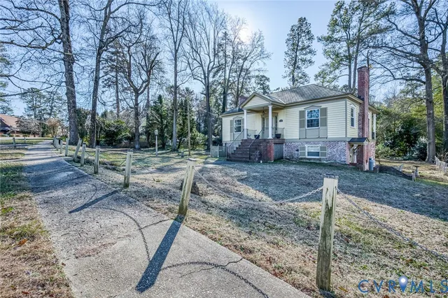 a view of a yard in front of a house with large trees