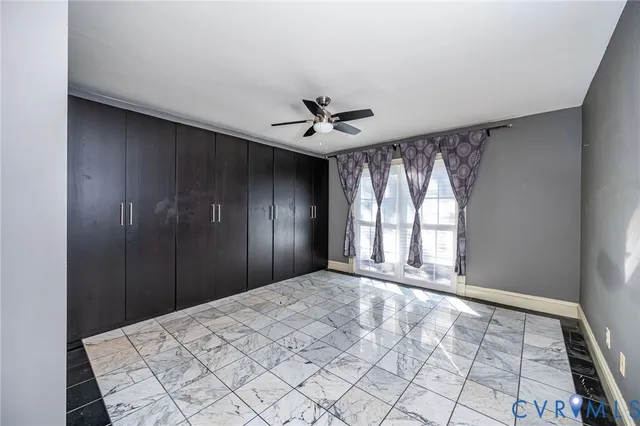 a large bedroom with a large bed and chandelier fan