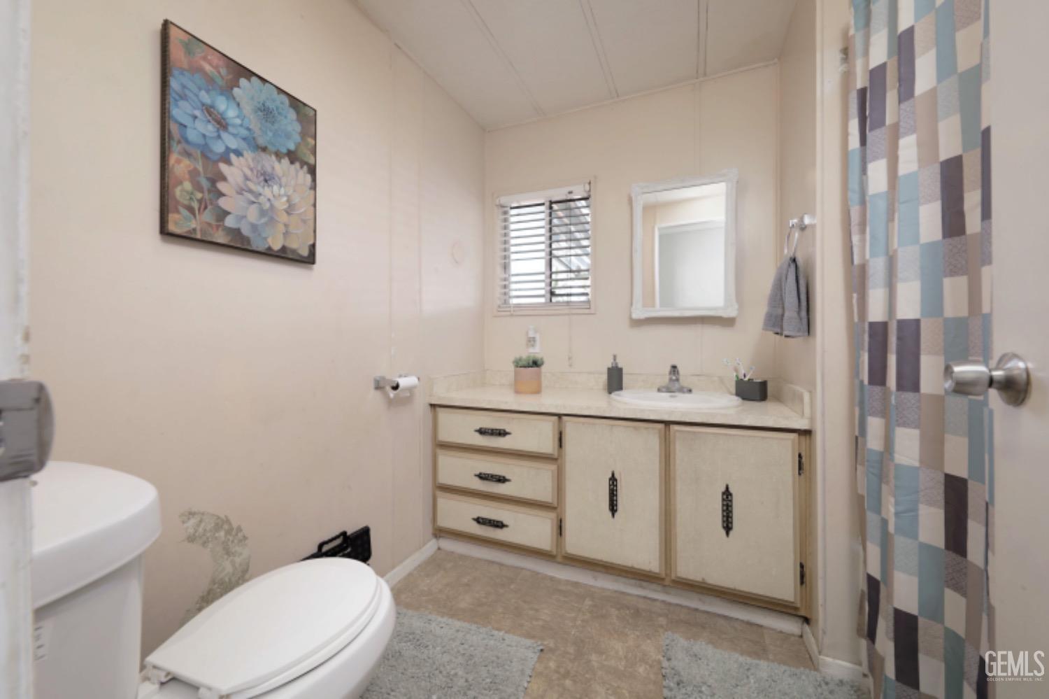 Undisclosed Address Bakersfield, CA 93306 - Photo 13 of 35 a bathroom with a toilet a sink mirror and vanity