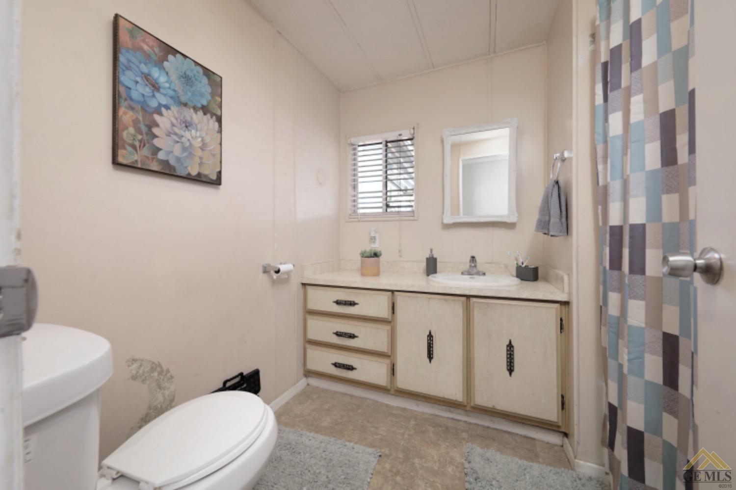 Undisclosed Address Bakersfield, CA 93306 - Photo 27 of 35 a bathroom with a toilet a sink mirror and vanity