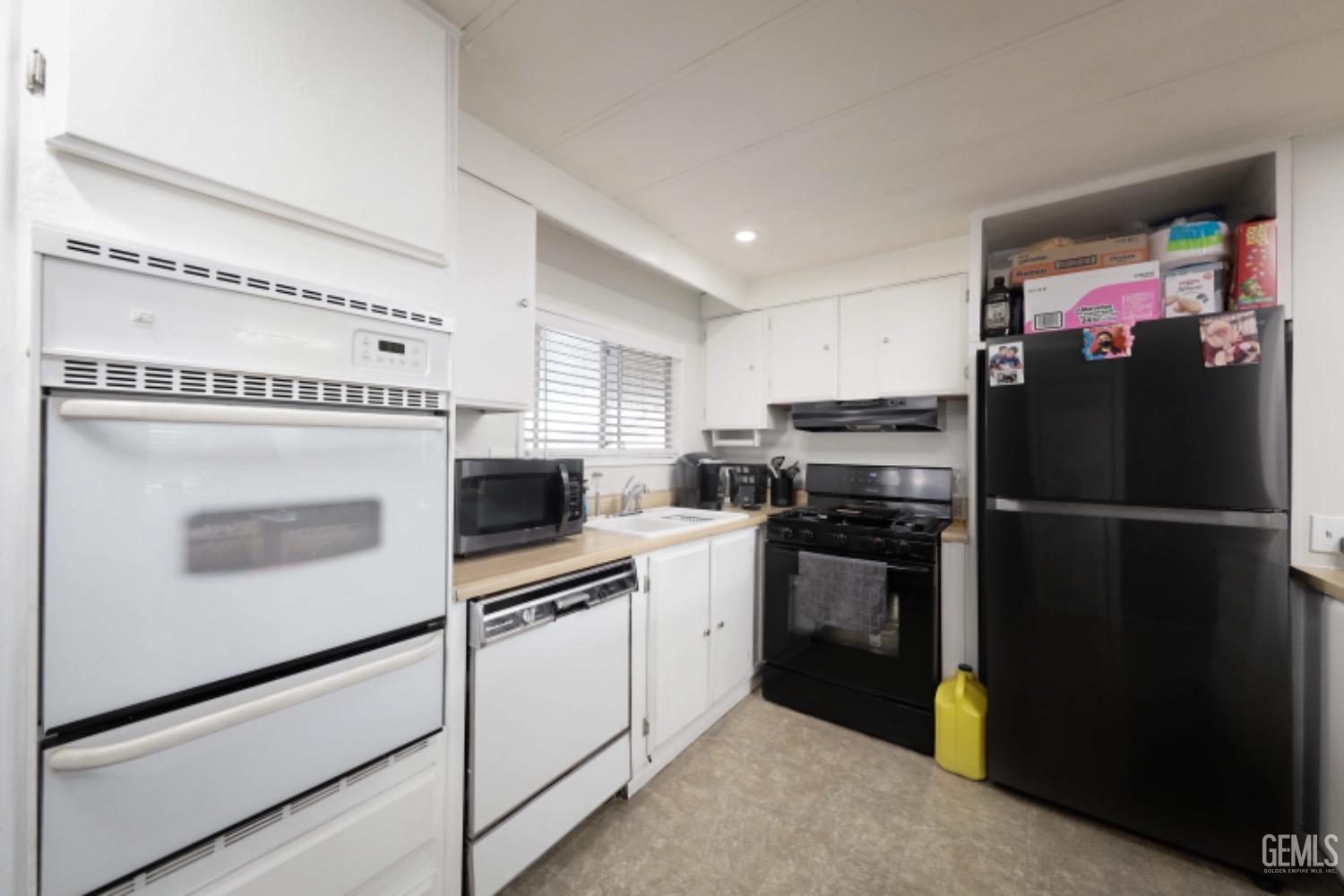 Undisclosed Address Bakersfield, CA 93306 - Photo 7 of 35 a kitchen with a refrigerator and a stove top oven