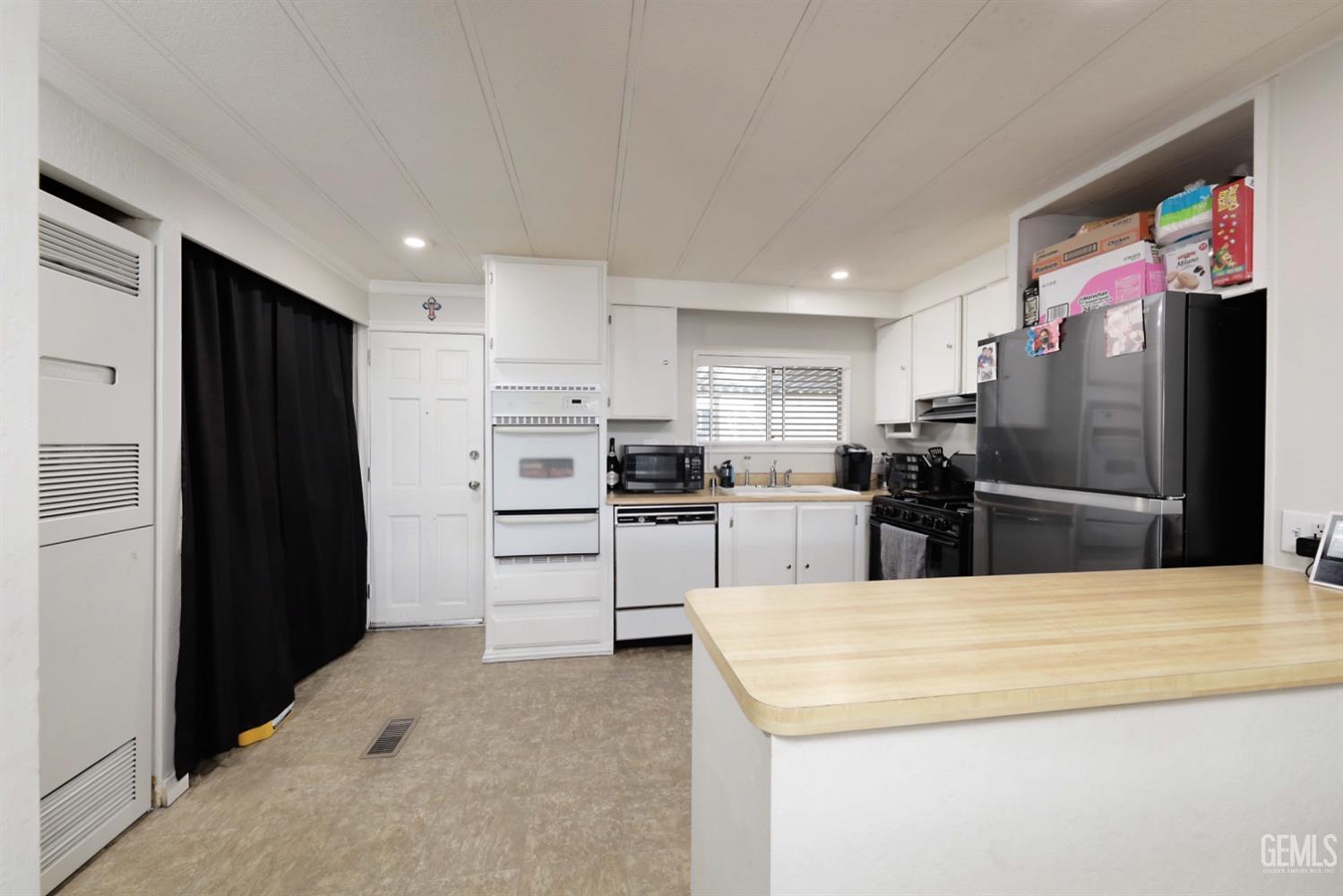 Undisclosed Address Bakersfield, CA 93306 - Photo 10 of 35 a kitchen with stainless steel appliances kitchen island granite countertop a refrigerator and a sink