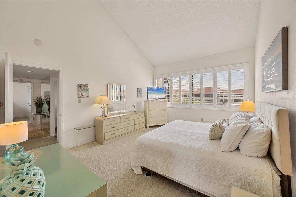 6285 Midnight Pass Road, Unit 403 Sarasota, FL 34242 - Photo 16 of 51 a bedroom with a large bed and wooden floor