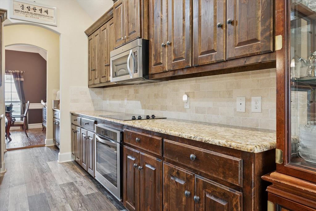 119 George Owens Road Ponder, TX 76259 - Photo 8 of 26 Rich wood cabinetry paired with light granite-look countertops