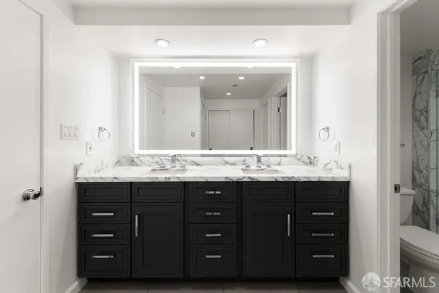 a bathroom with a granite countertop sink vanity and mirror
