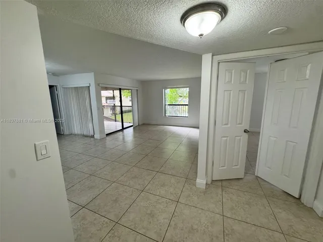 a view of a hallway with wooden floor and a bathroom