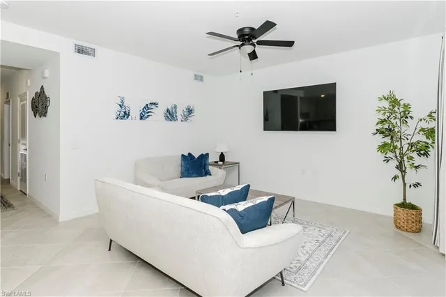 a living room with furniture and a potted plant