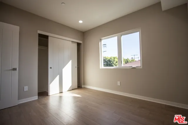 an empty room with wooden floor and a window