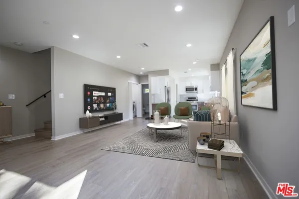 a living room with furniture and a wooden floor