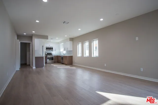 a view of empty room with wooden floor