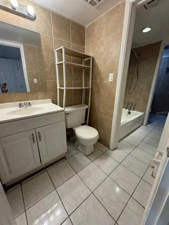 a bathroom with a granite countertop sink a toilet and a mirror