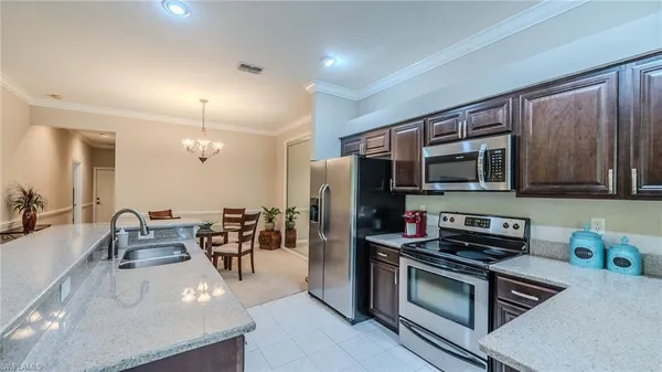 a kitchen with stainless steel appliances kitchen island granite countertop a stove and a sink
