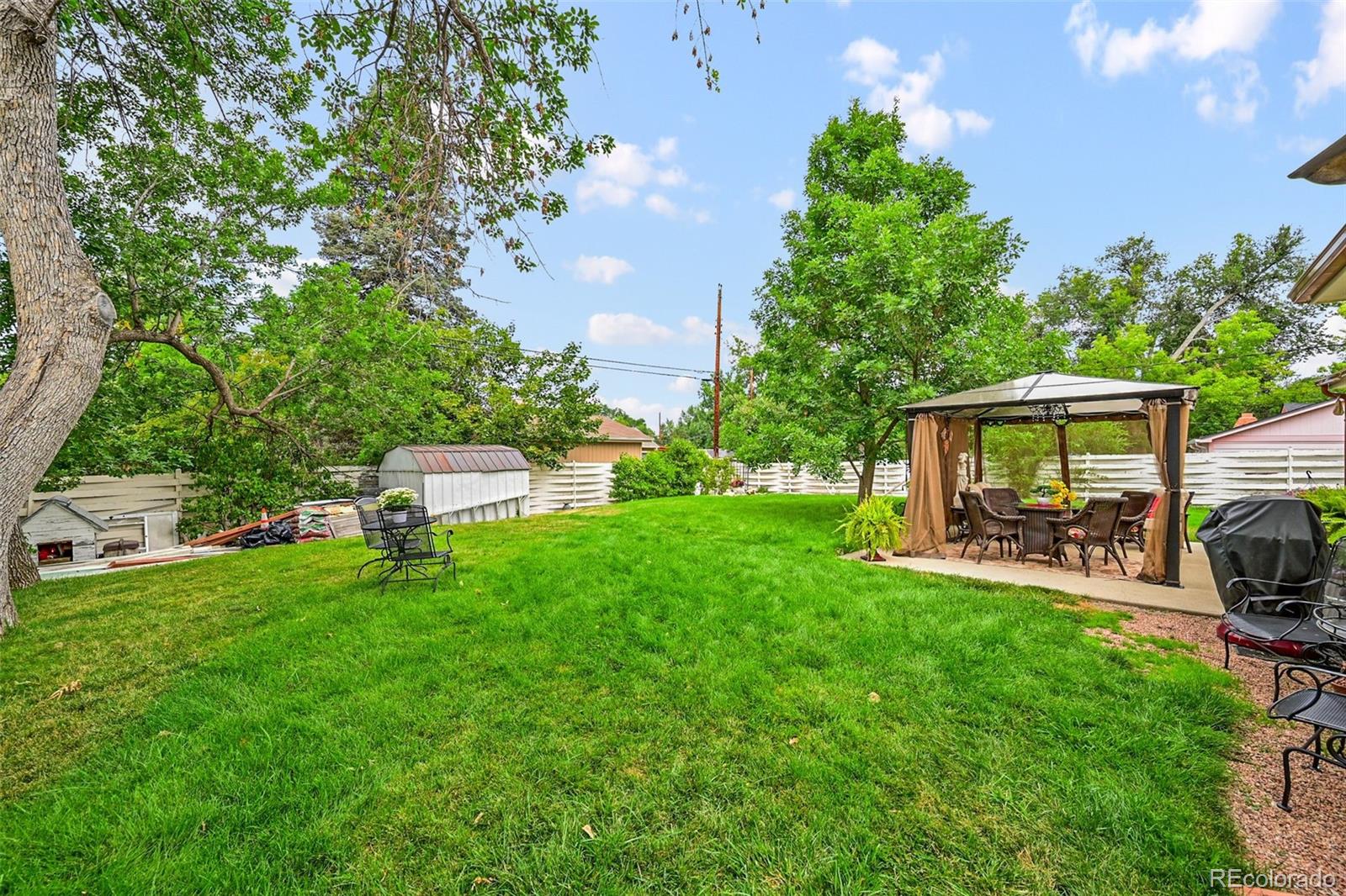 a view of a chair and table in backyard of the house