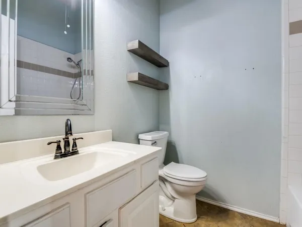 a bathroom with a toilet a sink and mirror