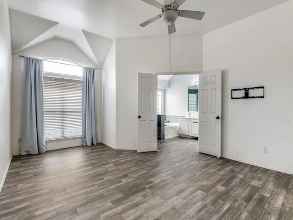 a view of a livingroom with wooden floor and a ceiling fan