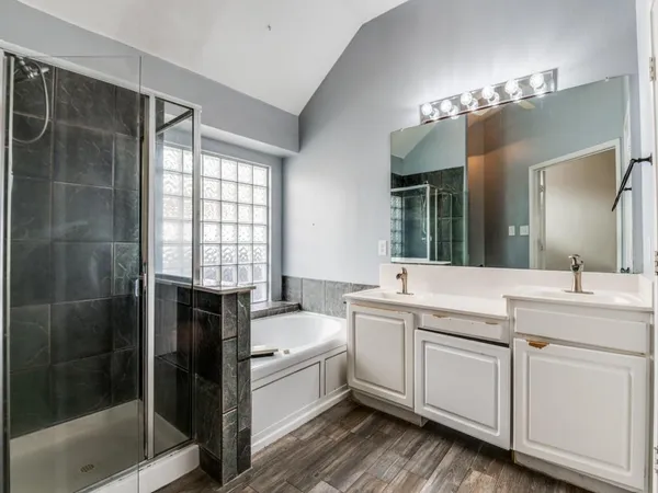 a bathroom with a tub sink and mirror