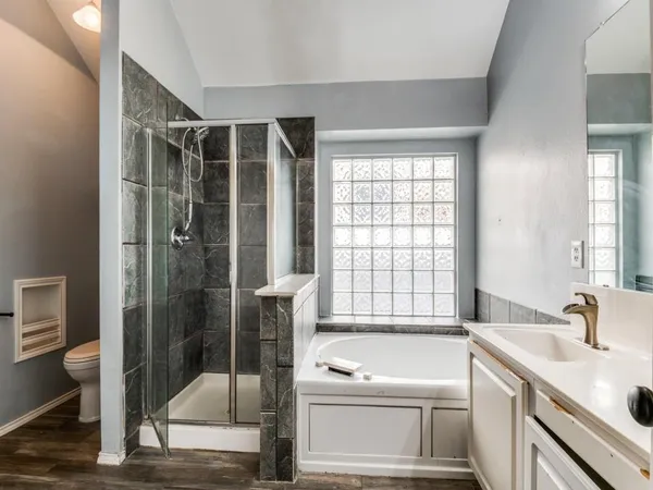 a bathroom with a granite countertop sink a toilet and shower