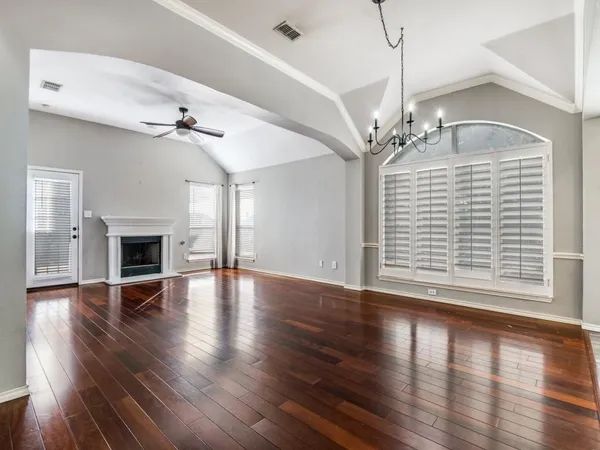 a view of empty room with wooden floor and fireplace
