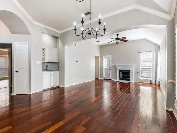 a view of a livingroom with wooden floor and a kitchen space