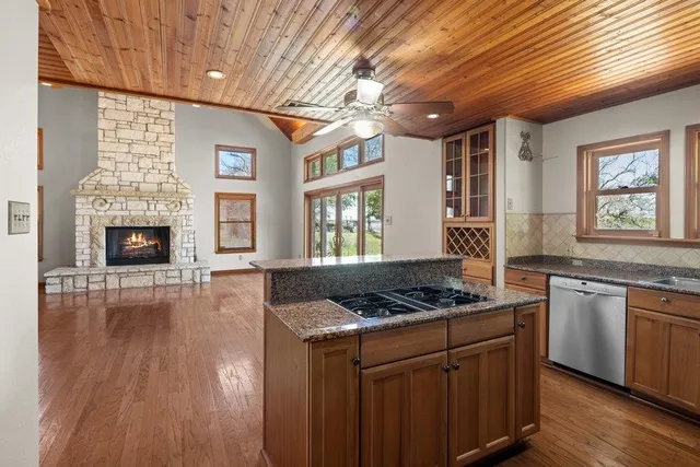 a kitchen with granite countertop a stove cabinets and wooden floor