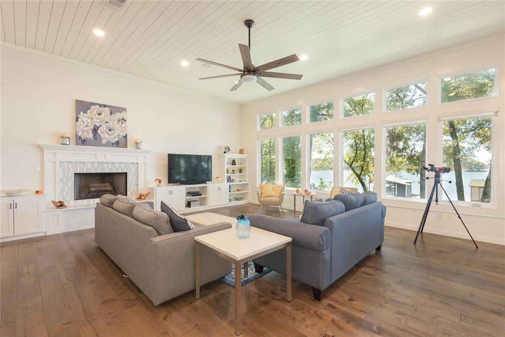 Spacious family room with high ceiling and a wall of windows.