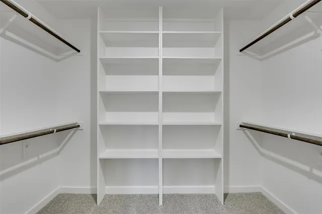 a view of walk in closet with empty racks