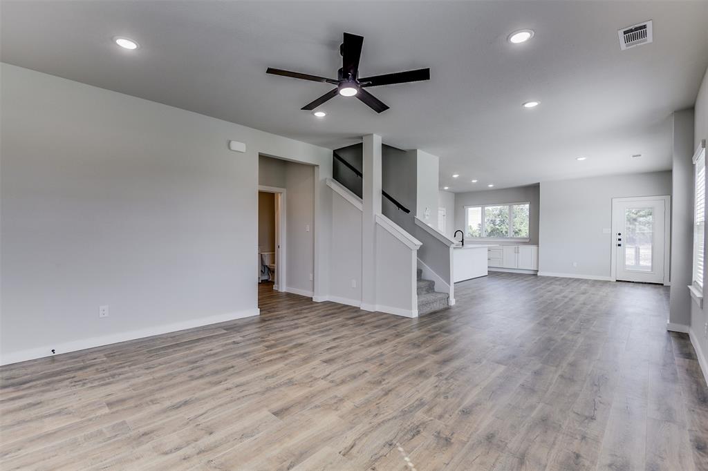 4042 Clovis Street Midlothian, TX 76065 - Photo 4 of 22 a view of an empty room with wooden floor and a ceiling fan