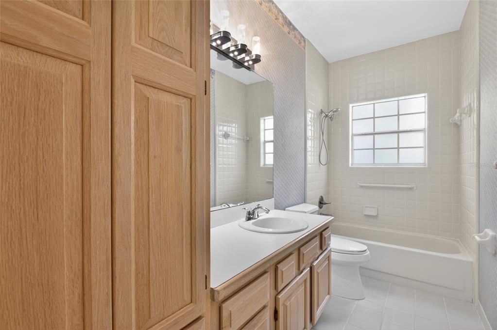9626 Southwest 53rd Road Gainesville, FL 32608 - Photo 17 of 23 a bathroom with a granite countertop sink a toilet and shower