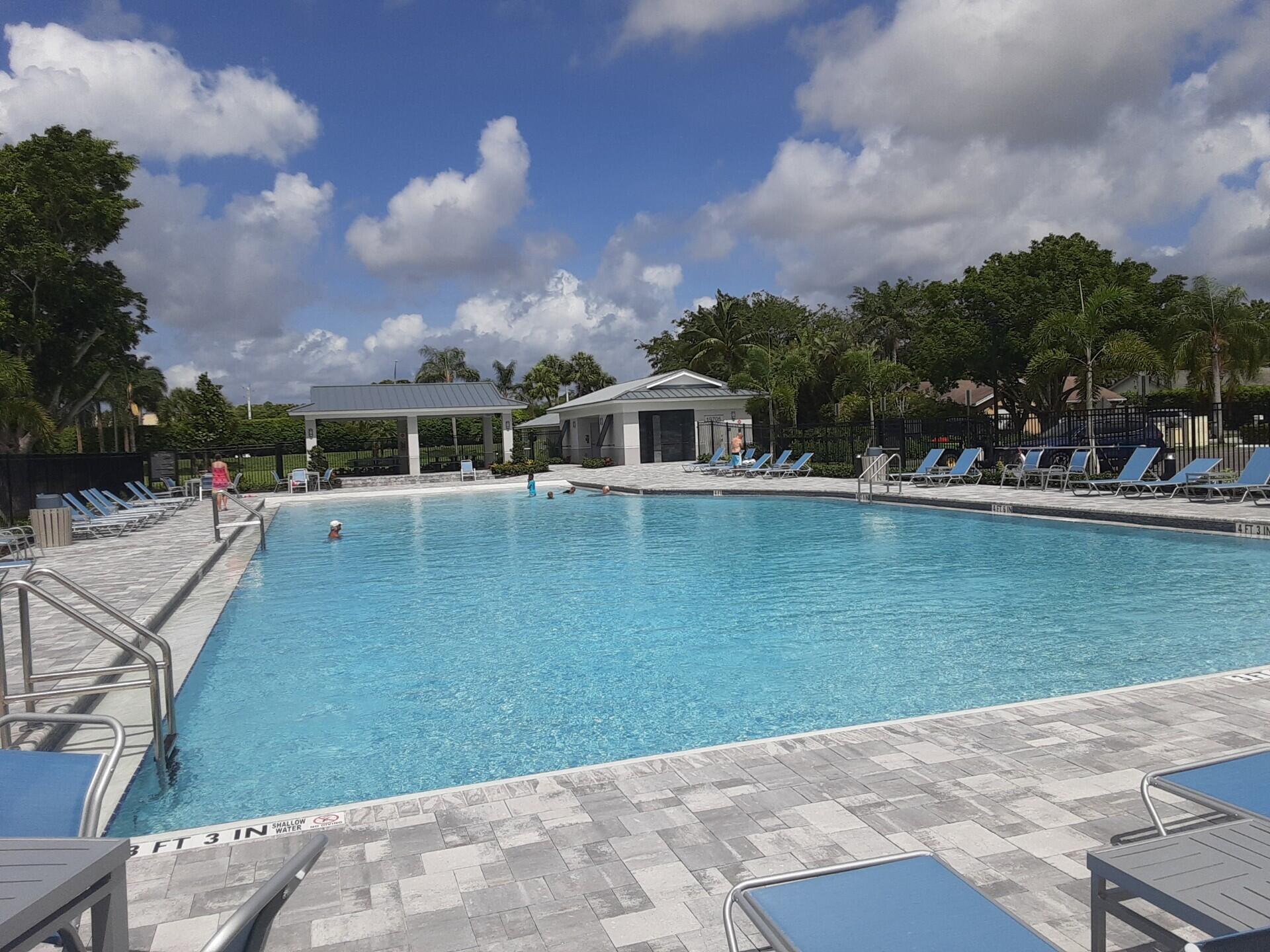 19620 Hampton Drive Boca Raton, FL 33434 - Photo 42 of 45 a view of a swimming pool with lawn chairs and plants
