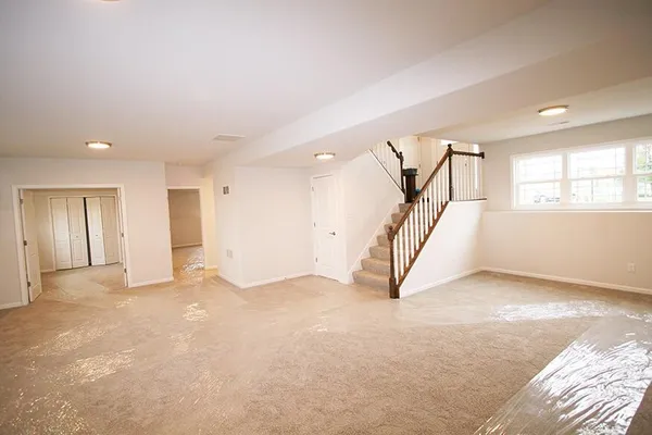an empty room with windows and stairs