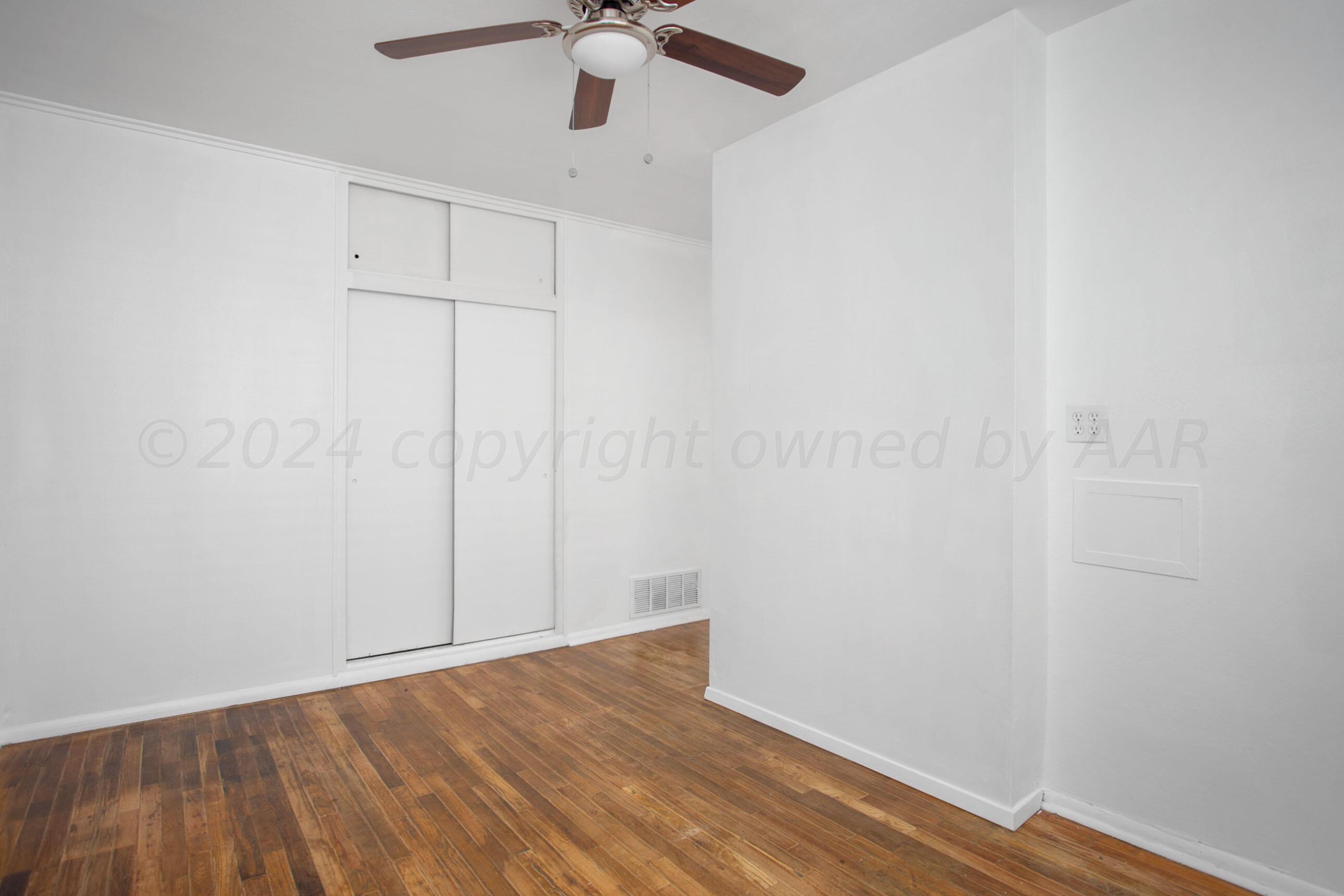 5318 Albert Avenue Amarillo, TX 79106 - Photo 11 of 24 an empty room with a hardwood and ceiling fan