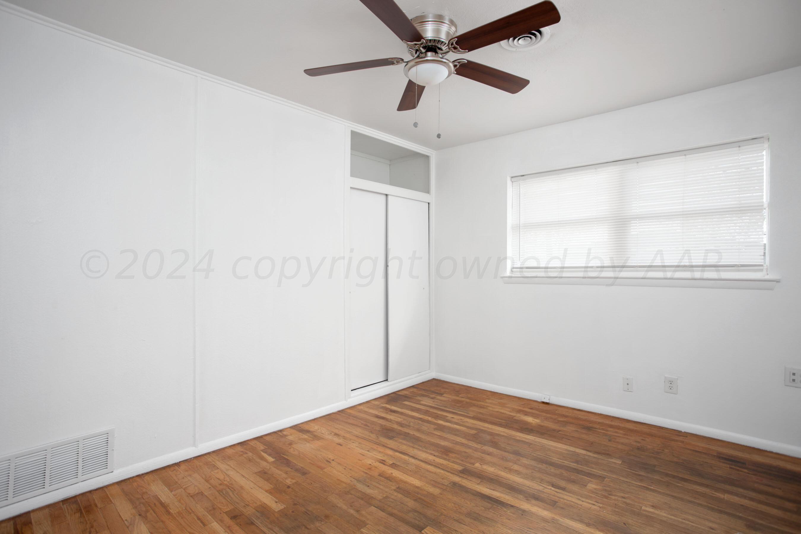 5318 Albert Avenue Amarillo, TX 79106 - Photo 12 of 24 an empty room with wooden floor fan and windows