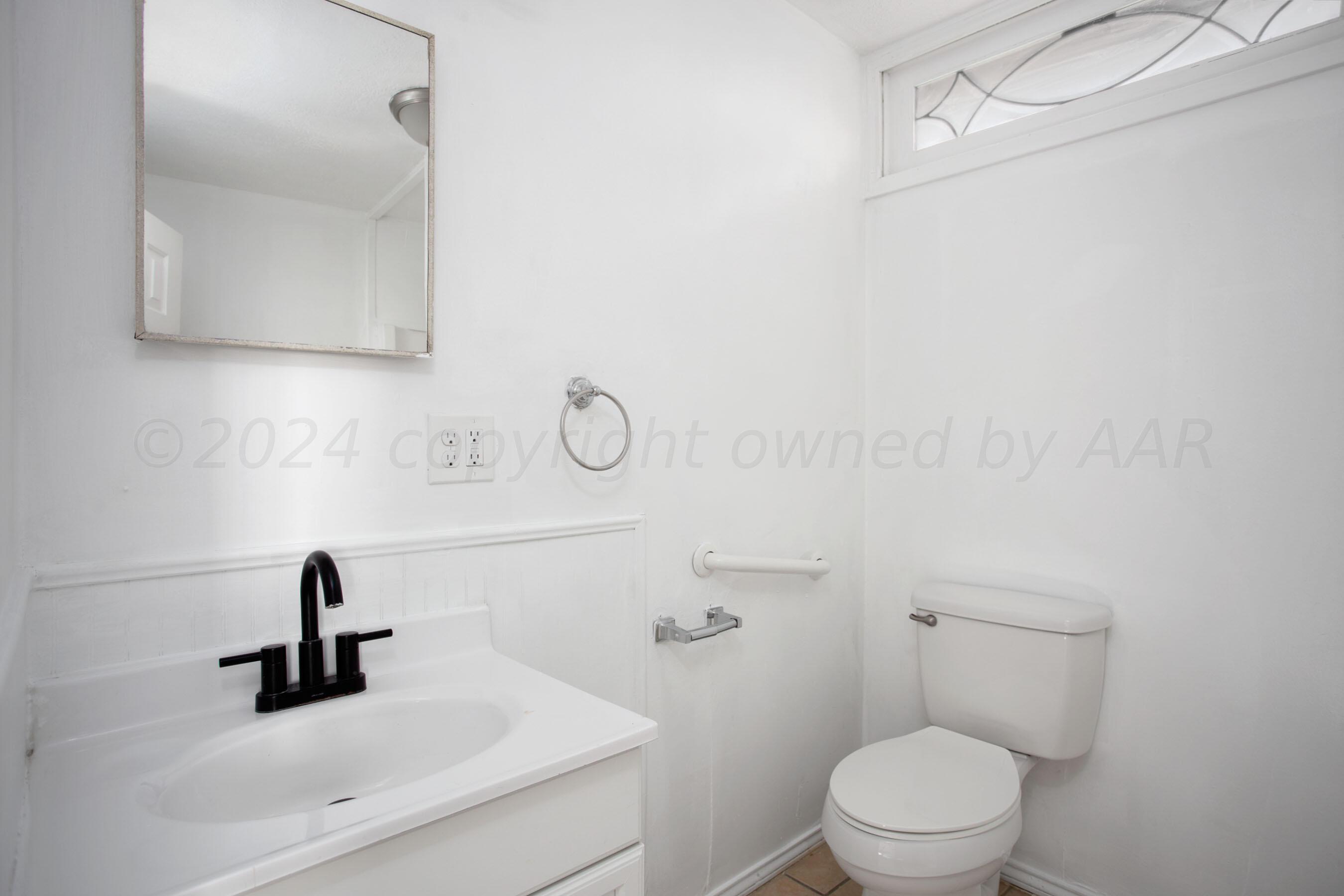 5318 Albert Avenue Amarillo, TX 79106 - Photo 19 of 24 a bathroom with a toilet sink and mirror