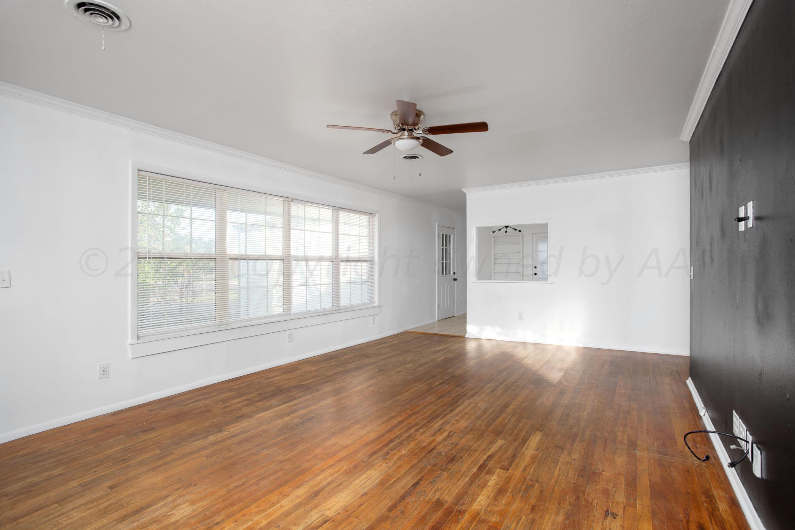 5318 Albert Avenue Amarillo, TX 79106 - Photo 4 of 24 a view of empty room with wooden floor and fan