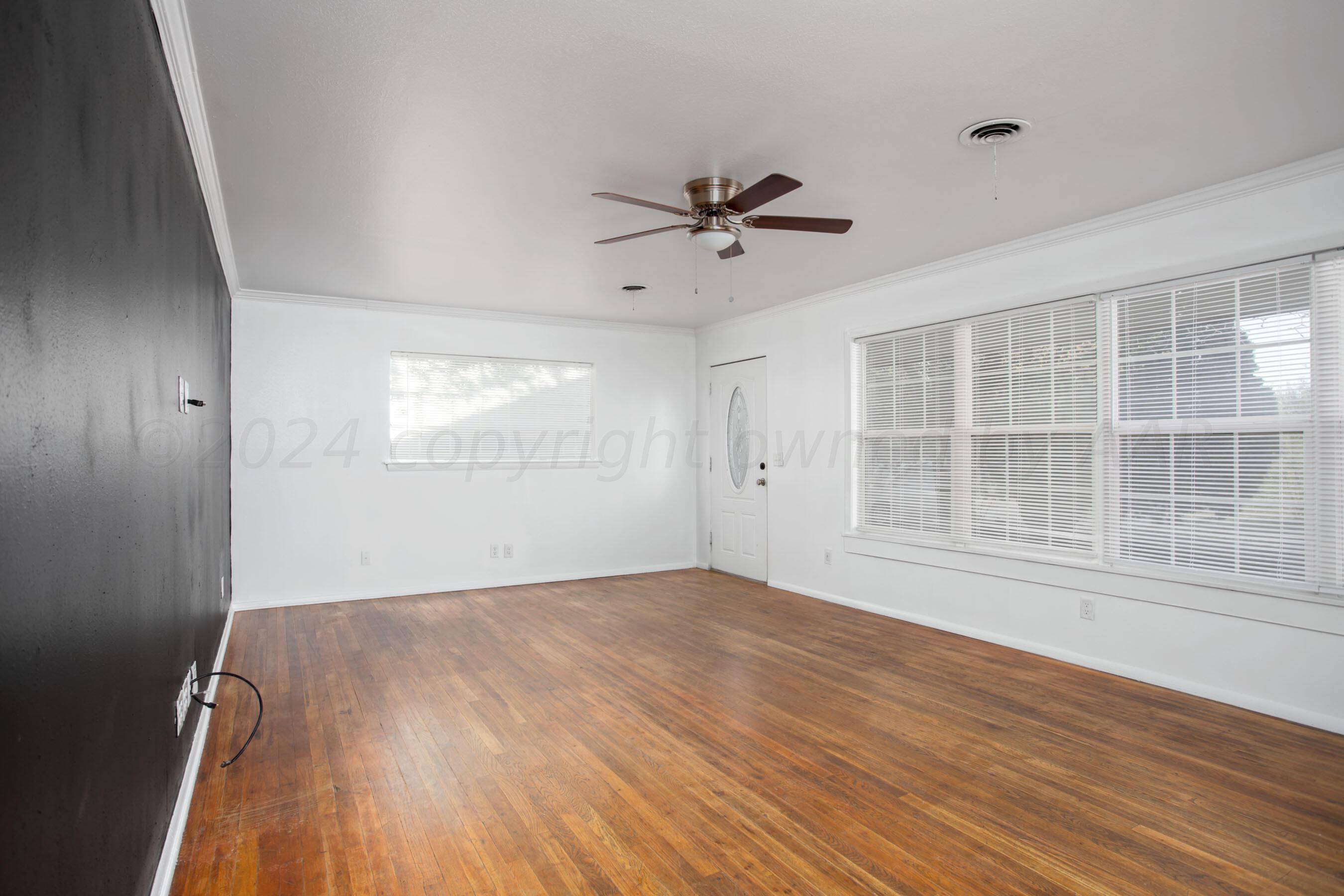 5318 Albert Avenue Amarillo, TX 79106 - Photo 5 of 24 a view of empty room with wooden floor and fan