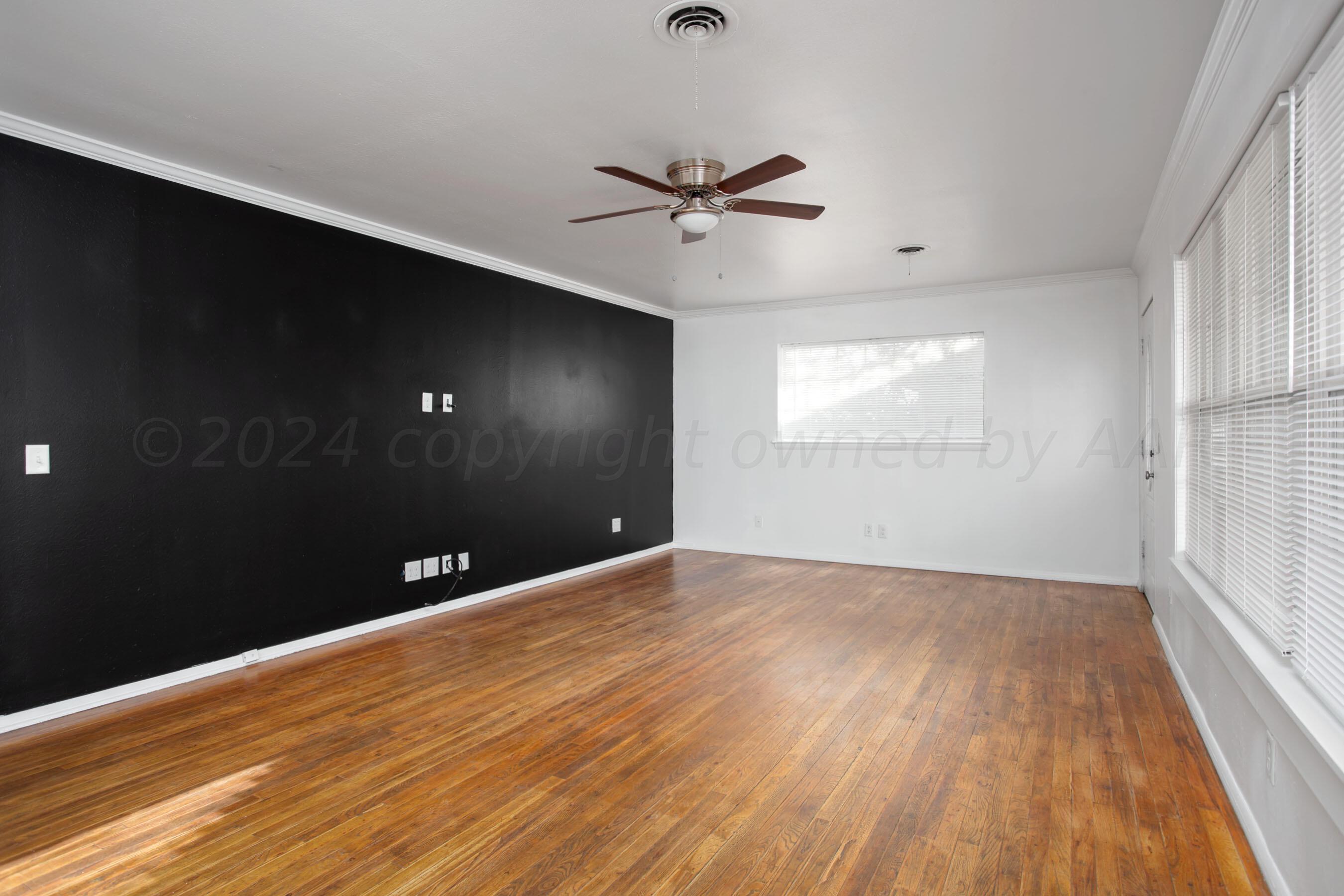 5318 Albert Avenue Amarillo, TX 79106 - Photo 6 of 24 wooden floor in an empty room with a window
