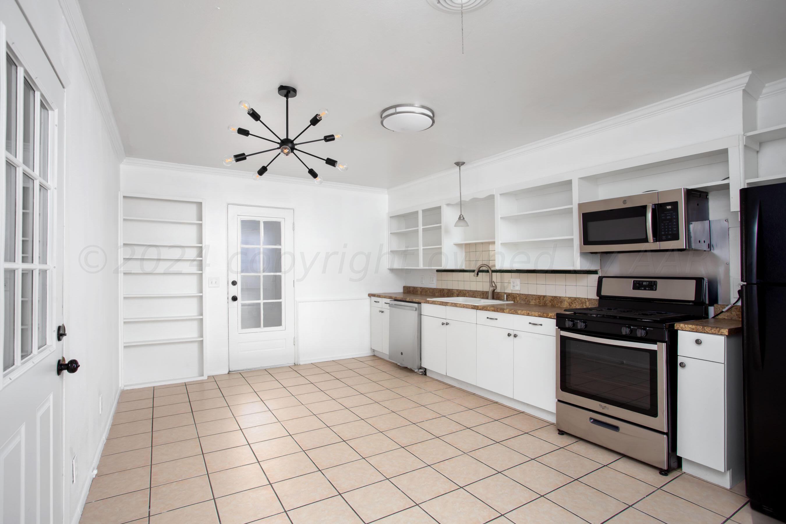 5318 Albert Avenue Amarillo, TX 79106 - Photo 7 of 24 a kitchen with stainless steel appliances a stove a sink and a refrigerator