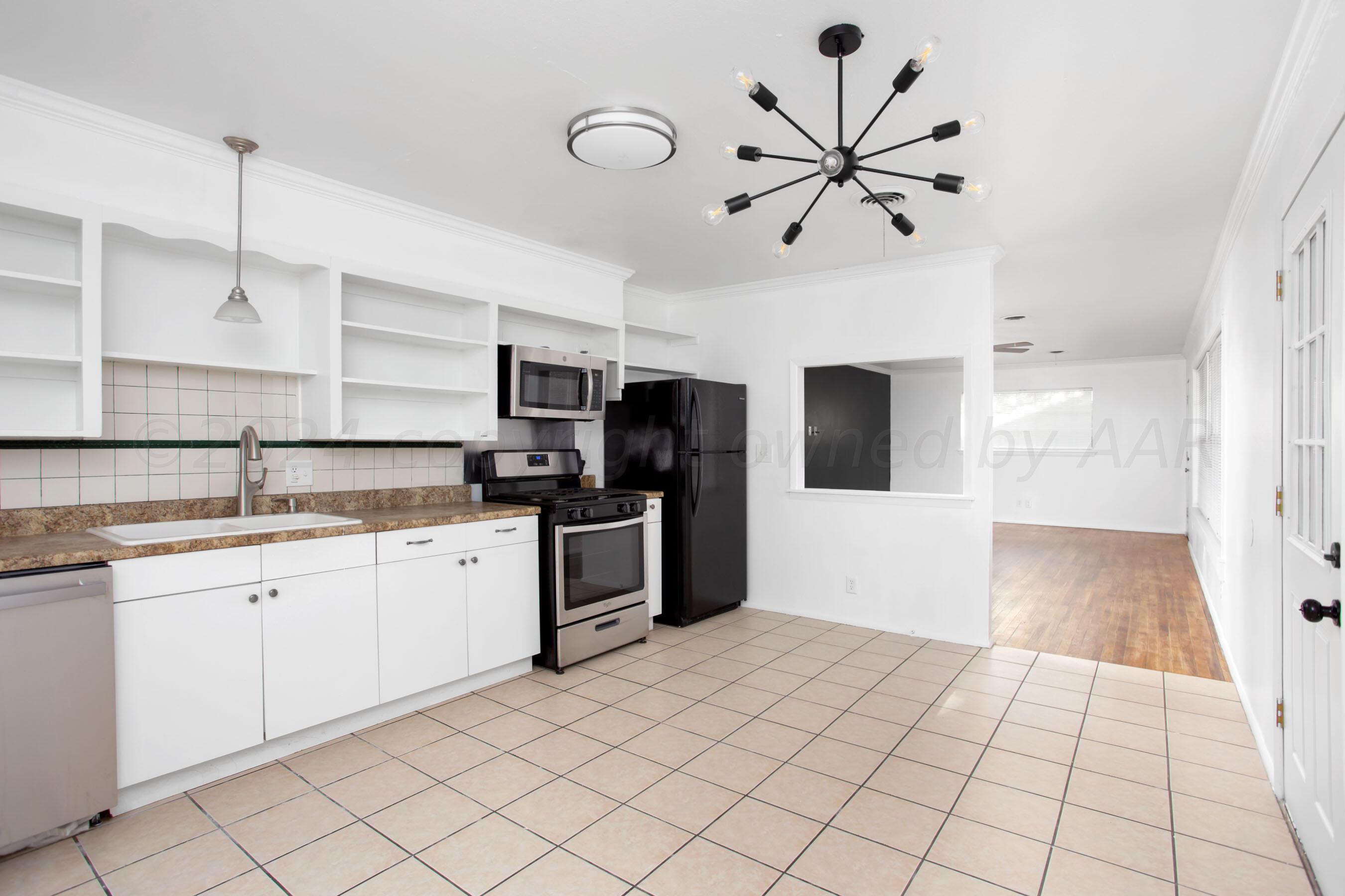 5318 Albert Avenue Amarillo, TX 79106 - Photo 9 of 24 a kitchen with stainless steel appliances a refrigerator sink and microwave