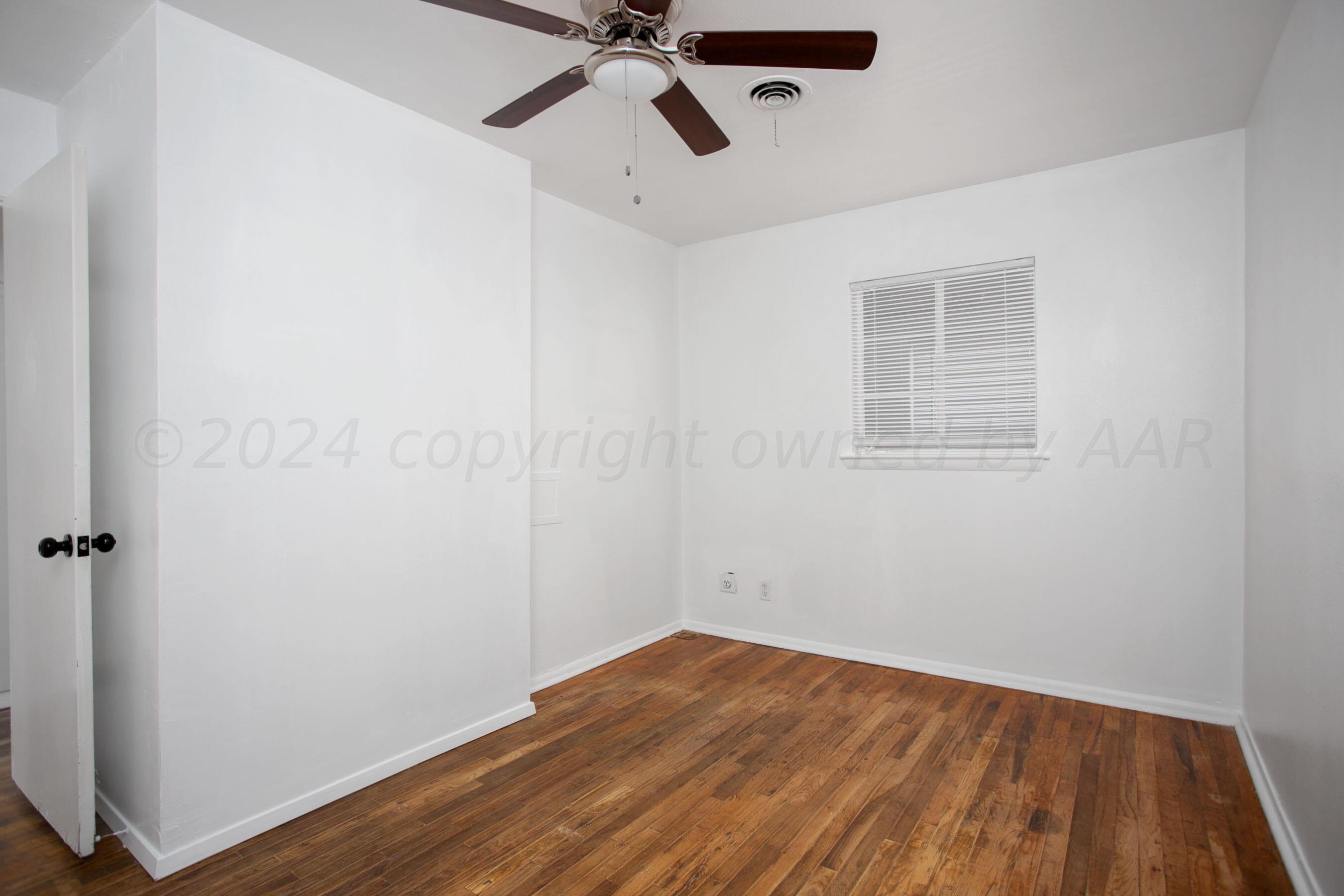 5318 Albert Avenue Amarillo, TX 79106 - Photo 10 of 24 an empty room with wooden floor and windows
