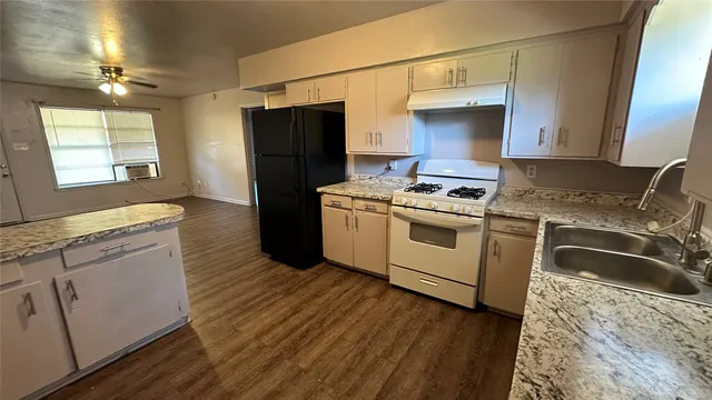 a kitchen with a stove a sink and a refrigerator