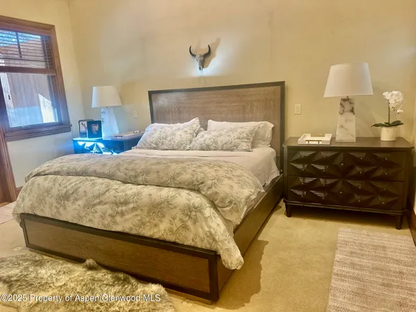 a bed sitting in a bedroom next to a lamp