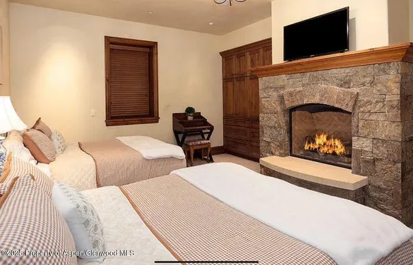 a bedroom with two beds and a fireplace