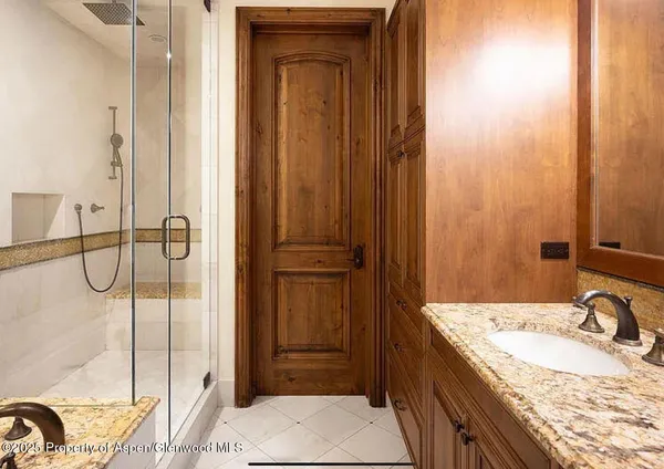 a bathroom with a granite countertop sink and a mirror